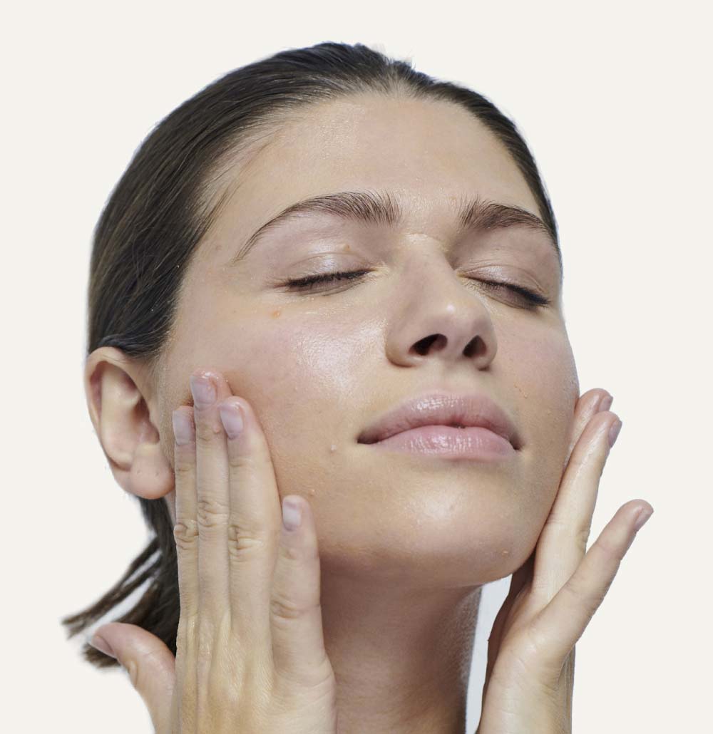 Model applying Gotu Kola to her face